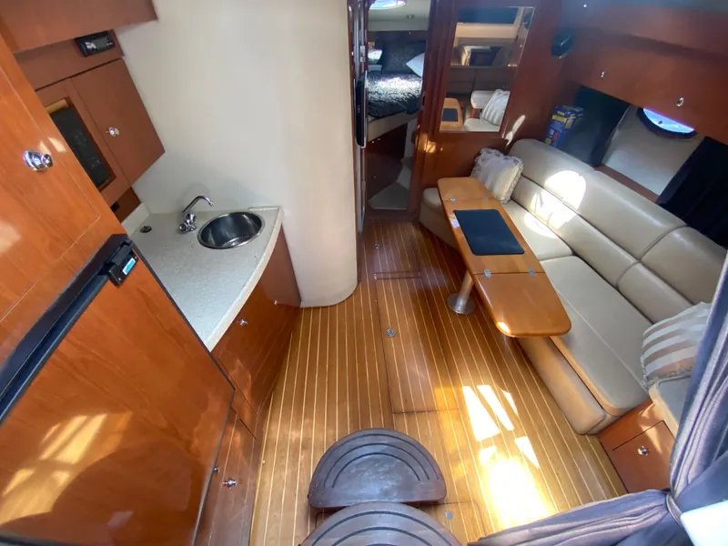 Slide: The Image of 2007 Regal 3760 Sportyacht interior with wood flooring, kitchenette, and seating area. - 29