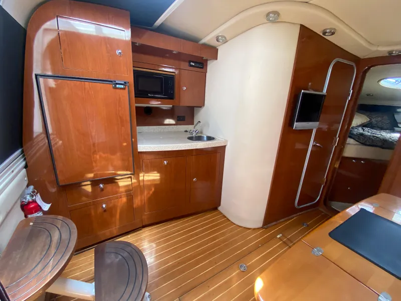 Slide: The Image of 2007 Regal 3760 Sportyacht interior with kitchenette, wood cabinetry, and seating area. - 33