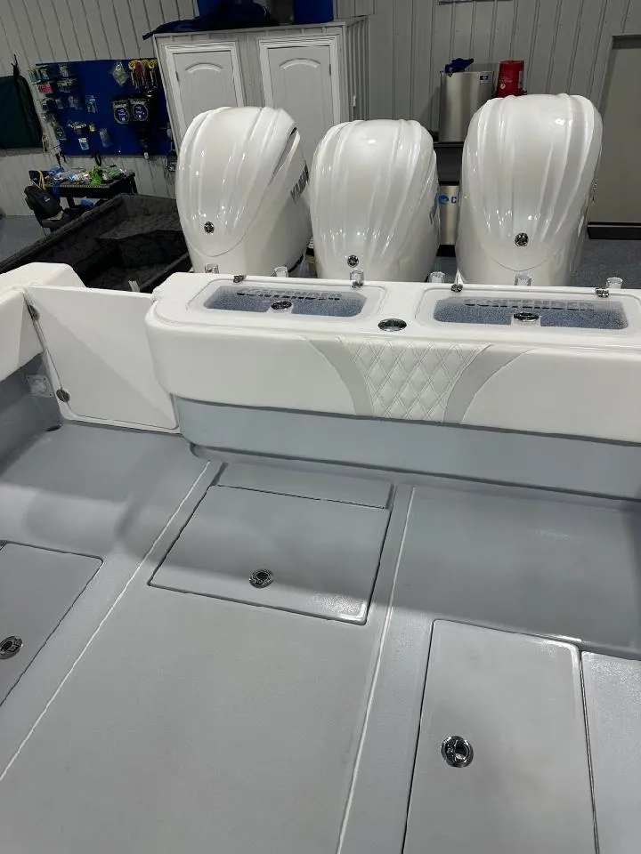 Slide: The Image of 2024 Contender 39 ST boat with triple outboard engines in a showroom. - 9