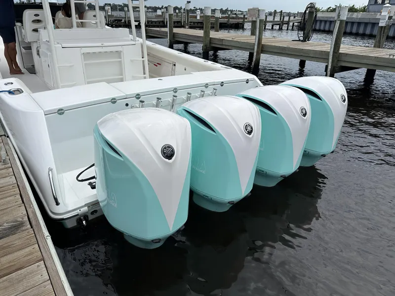 Slide: The Image of 2017 Everglades 435 Center Console boat with four teal outboard engines docked. - 10