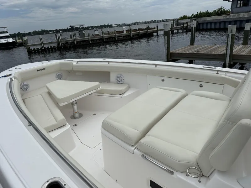 Slide: The Image of 2017 Everglades 435 Center Console boat with white seating, docked by a marina. - 16