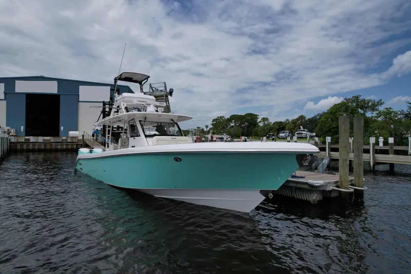 Slide: The Image of 2017 Everglades 435 Center Console boat docked at marina under cloudy sky. - 2