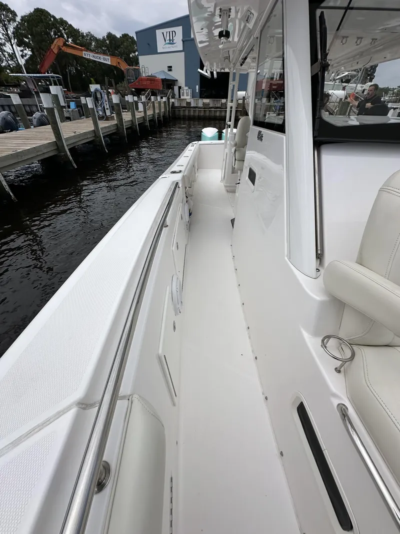 Slide: The Image of 2017 Everglades 435 Center Console boat docked at marina, showcasing sleek white deck design. - 32