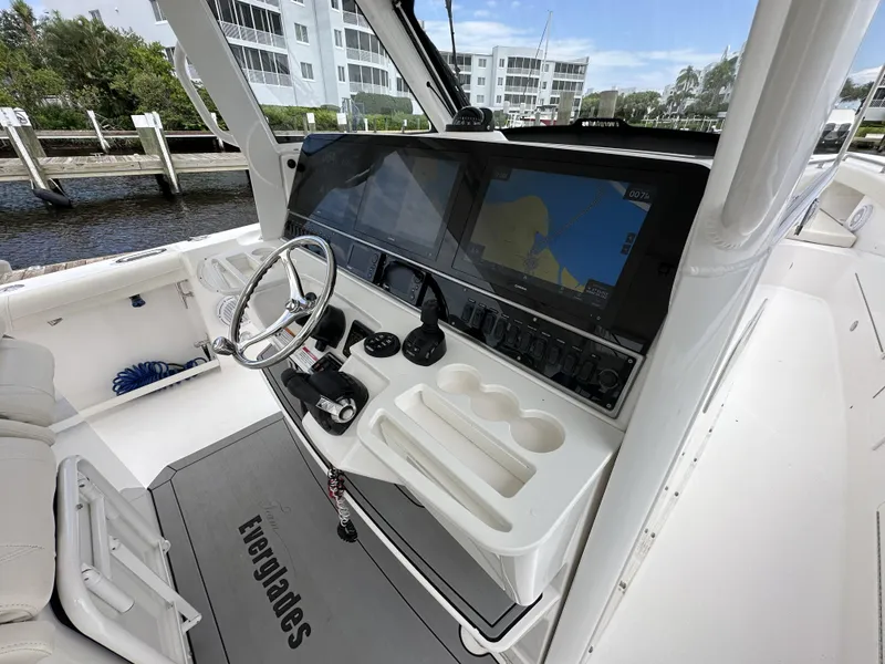 Slide: The Image of 2017 Everglades 435 Center Console boat cockpit with steering wheel and navigation screens. - 33