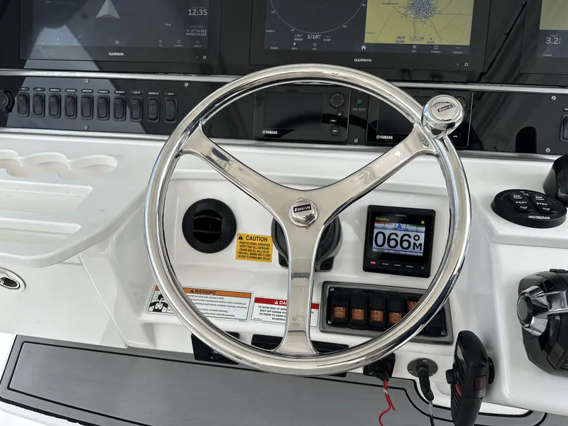 Slide: The Image of Steering wheel of a 2017 Everglades 435 Center Console boat with navigation displays. - 37