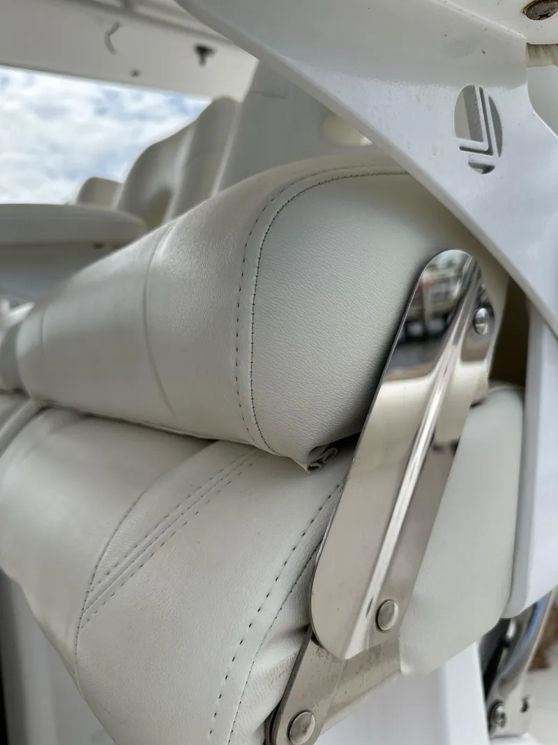 Slide: The Image of Close-up of 2017 Everglades 435 Center Console boat seat with white leather and metal accents. - 48