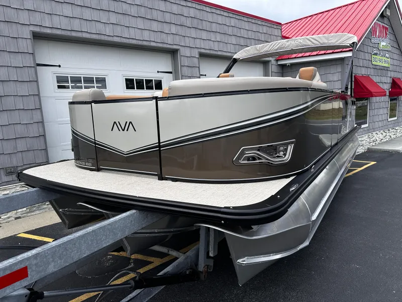 Slide: The Image of 2025 Avalon 2385 LSZ Quad Lounger Tri Toon on trailer, parked outside building. - 3