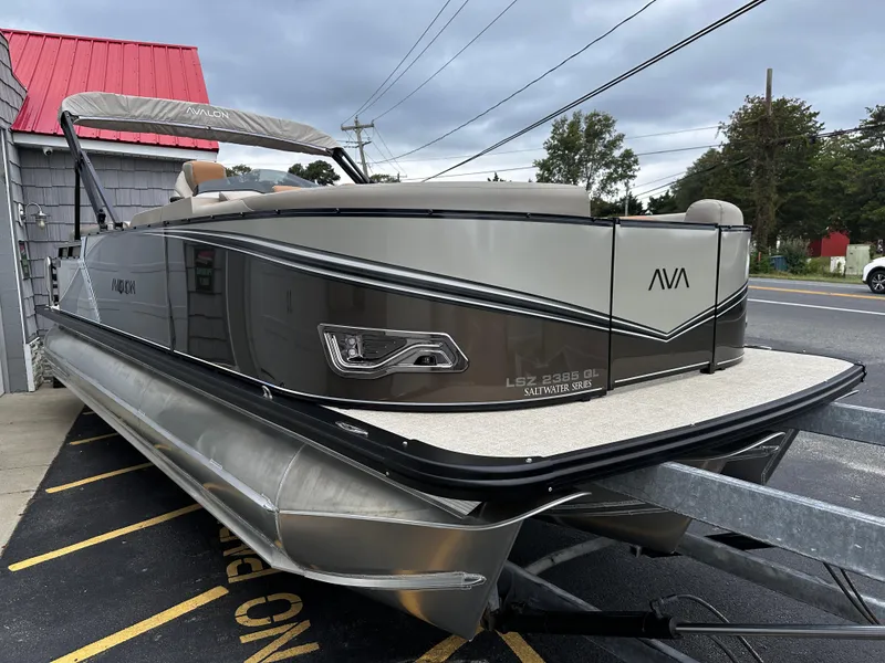 Slide: The Image of 2025 Avalon 2385 LSZ Quad Lounger Tri Toon boat, high performance, parked outdoors. - 7