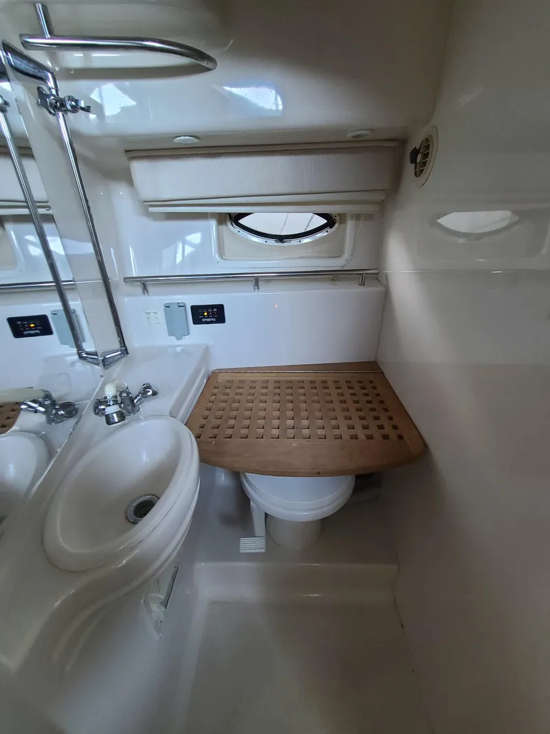 Slide: The Image of 2002 Monterey 322 Cruiser bathroom with sink, toilet, and wooden cover. - 10