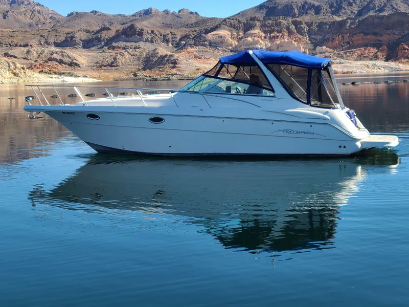 Slide: The Image of 2002 Monterey 322 Cruiser on calm lake with mountainous backdrop. - 3