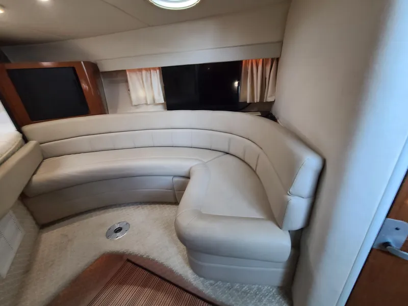 Slide: The Image of 2002 Monterey 322 Cruiser interior with curved beige seating and carpeted floor. - 8
