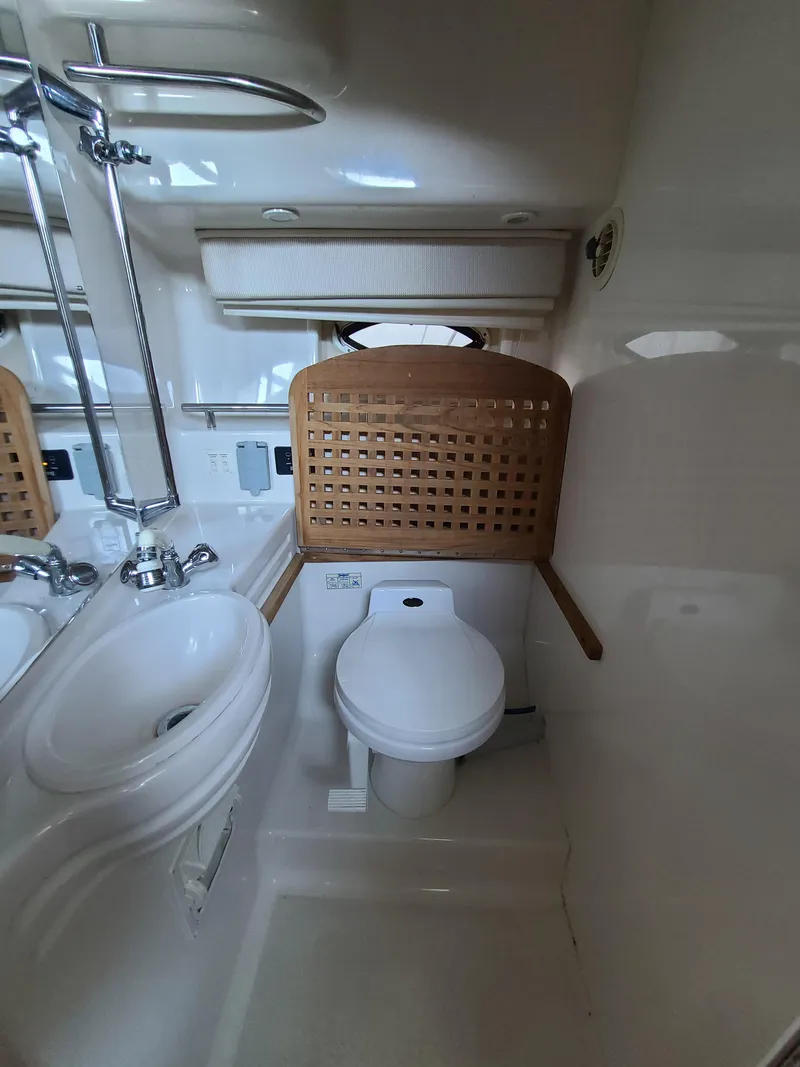 Slide: The Image of 2002 Monterey 322 Cruiser bathroom with sink, toilet, and wooden accents. - 9