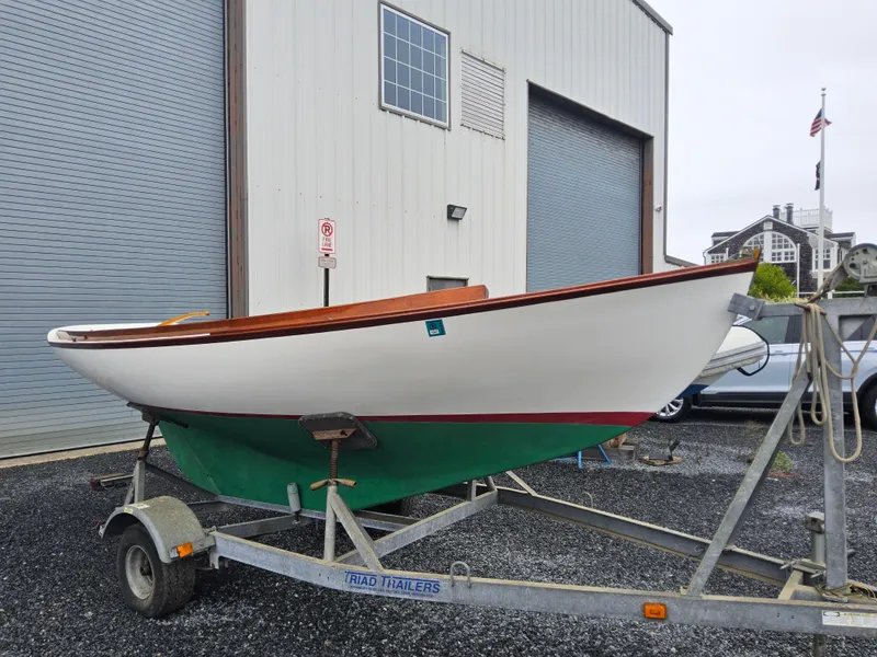 The Image of 2004 Herreshoff H-12 1/2 Gaff Rig sailboat on trailer outside warehouse. - 0