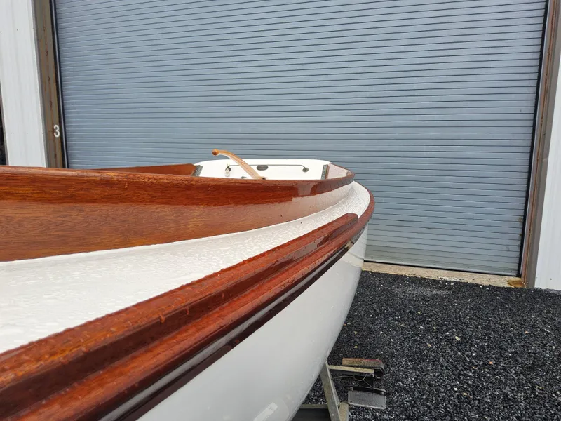 Slide: The Image of 2004 Herreshoff H-12 1/2 Gaff Rig sailboat with wooden trim near a garage door. - 10