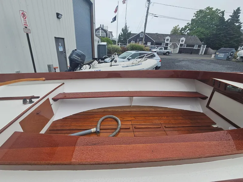 Slide: The Image of 2004 Herreshoff H-12 1/2 Gaff Rig boat interior with wooden seating and deck. - 5