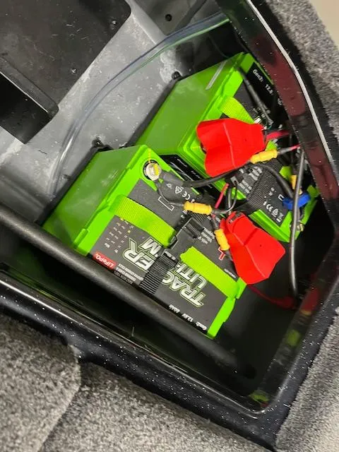 Slide: The Image of 2025 Ranger Z520R boat batteries with red connectors in storage compartment. - 16