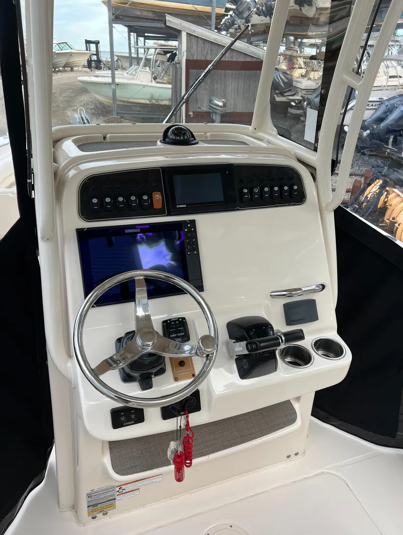 Slide: The Image of 2020 Grady-White 257 Fisherman boat console with steering wheel and navigation controls. - 2