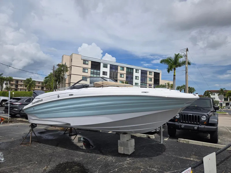 The Image of 2025 SouthWind 2200 SD boat on display in a parking lot with palm trees. - 0
