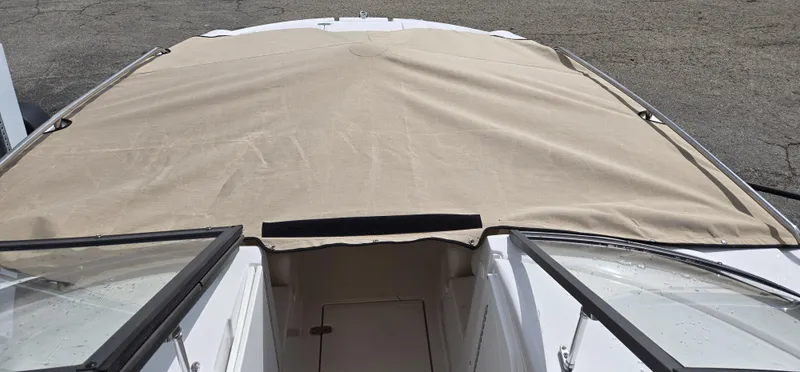 Slide: The Image of 2025 SouthWind 2200 SD boat with beige cover, docked on concrete surface. - 16