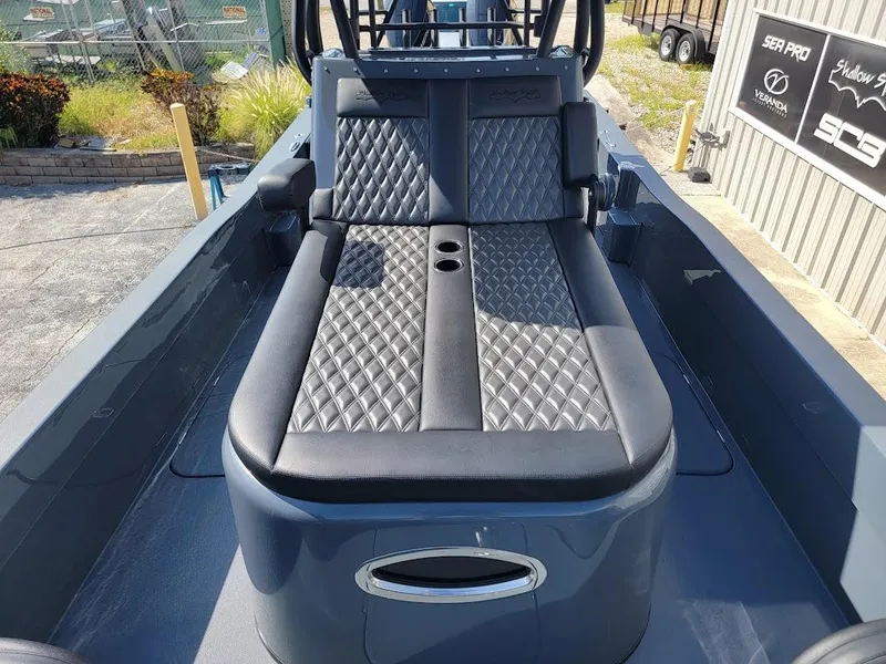 Slide: The Image of 2026 Shallow Sport 32 X3 boat with diamond-stitched seating in a marina setting. - 29