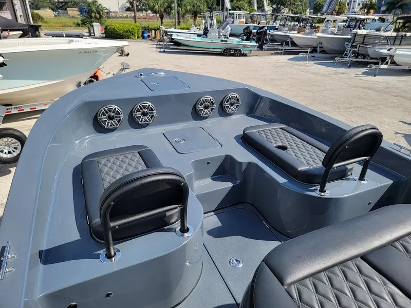 Slide: The Image of 2026 Shallow Sport 32 X3 boat interior with seating and speakers in a marina. - 30