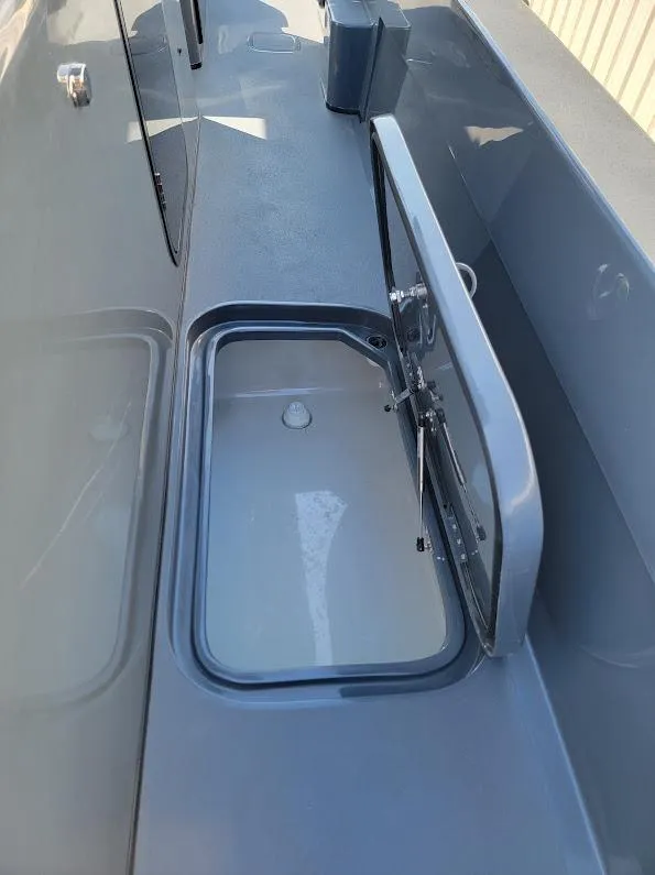 Slide: The Image of 2026 Shallow Sport 32 X3 boat with open storage compartment. - 34