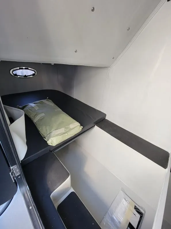 Slide: The Image of 2026 Shallow Sport 32 X3 cabin interior with bed and porthole. - 38