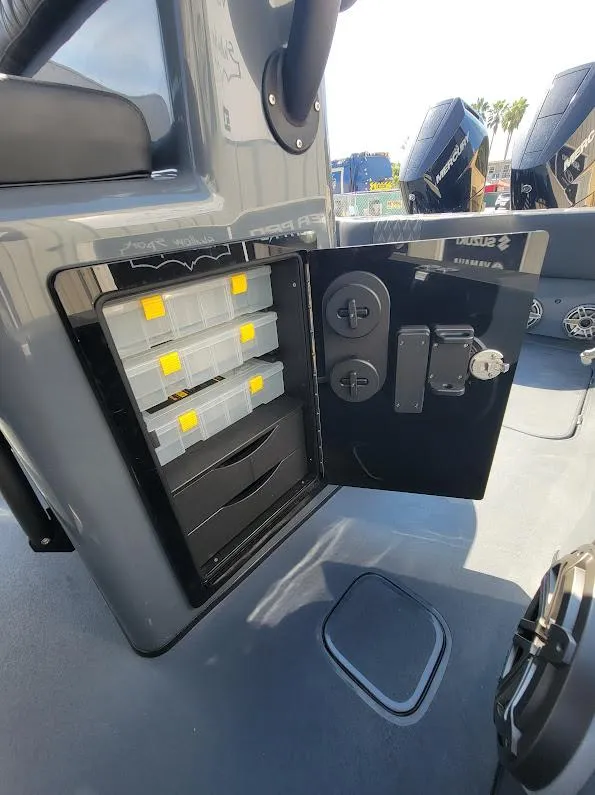 Slide: The Image of 2026 Shallow Sport 32 X3 boat storage compartment with organized tackle boxes. - 40