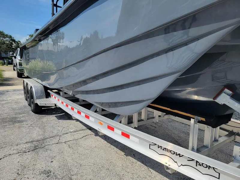 Slide: The Image of 2026 Shallow Sport 32 X3 boat on trailer, sleek design, parked outdoors. - 8