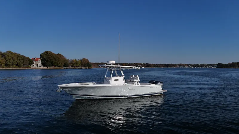 Slide: The Image of 2022 Southport 27 FE boat on calm water under clear blue sky. - 3
