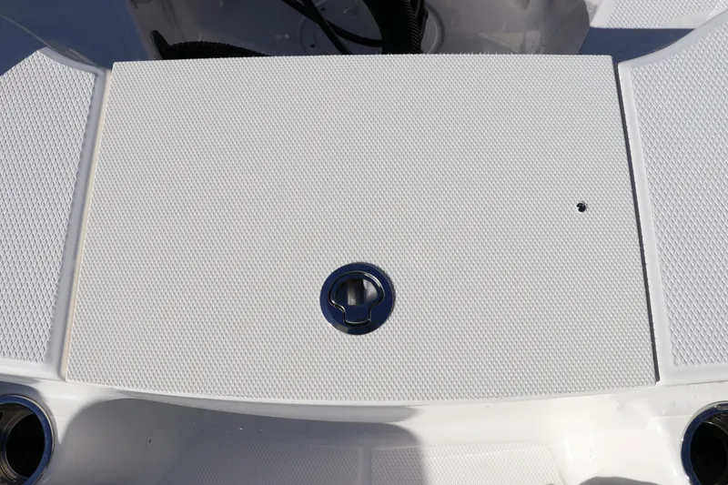 Slide: The Image of 2025 Robalo R200 Center Console boat deck with textured surface and circular latch. - 11