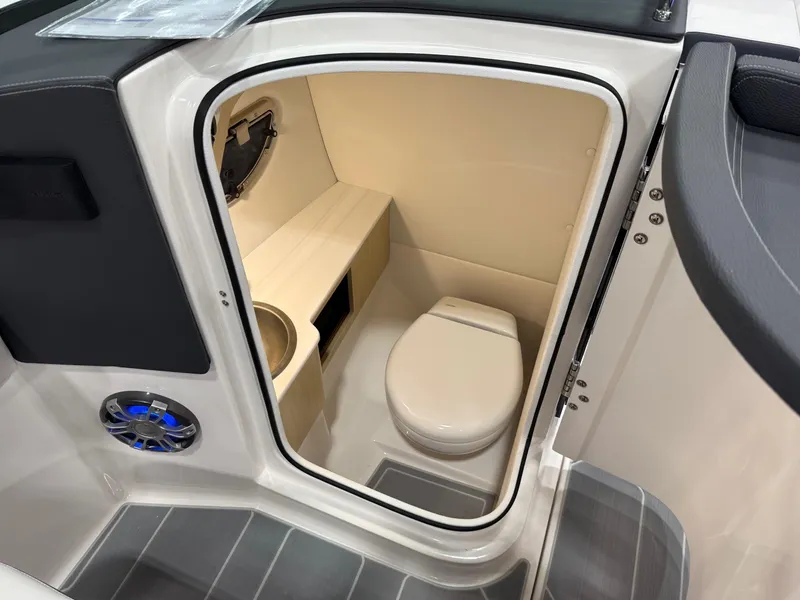 Slide: The Image of 2025 Regal LS6 boat interior with white seating, glass windshields, and a wooden table. - 6