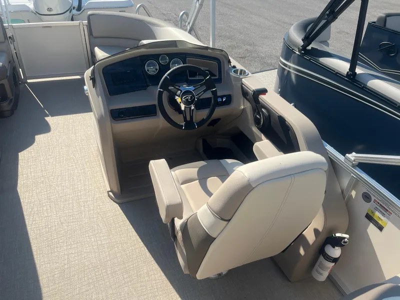Slide: The Image of 2024 Avalon 2385 LSZ Quad Lounger boat interior with steering console and seating. - 6