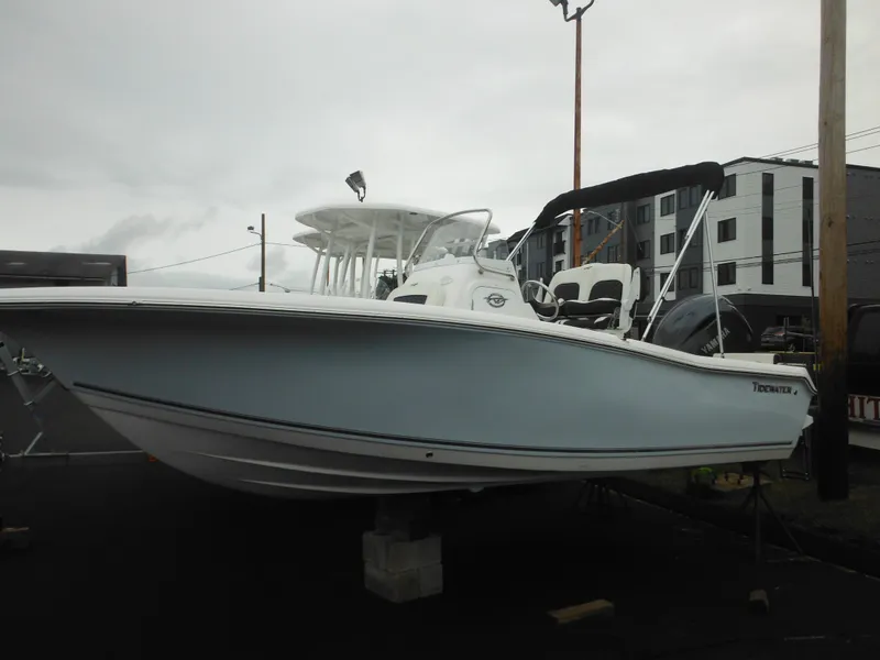 Slide: The Image of 2025 Tidewater 198 CC Adventure boat displayed outdoors on a cloudy day. - 0