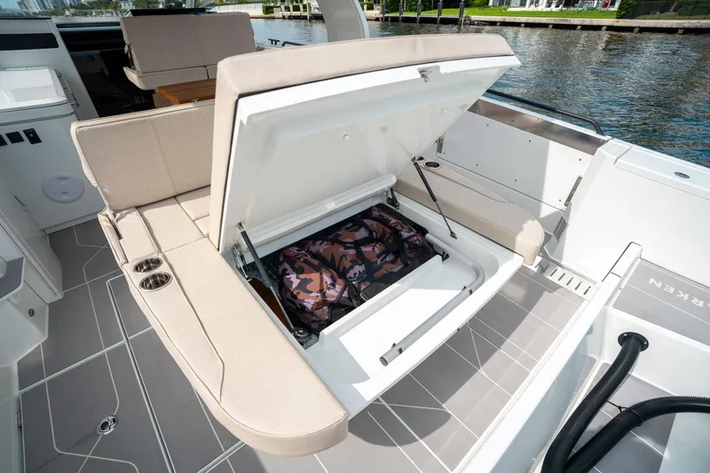 Slide: The Image of 2025 Quarken 35 Sport Tourer boat with open storage compartment and camo bag. - 14
