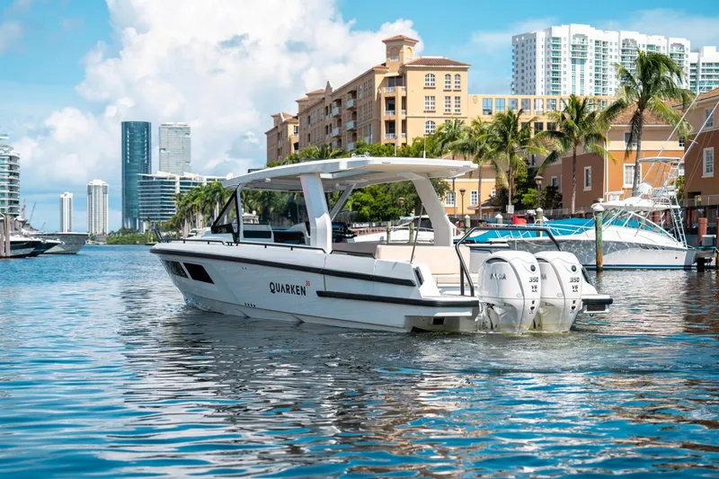 Slide: The Image of 2025 Quarken 35 Sport Tourer boat cruising in a sunny urban marina setting. - 6
