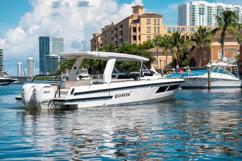 Slide: The Image of 2025 Quarken 35 Sport Tourer boat docked in a scenic urban marina. - 8