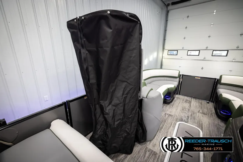 Slide: The Image of 2025 Avalon Catalina Entertainer interior with seating and privacy curtain in showroom. - 21