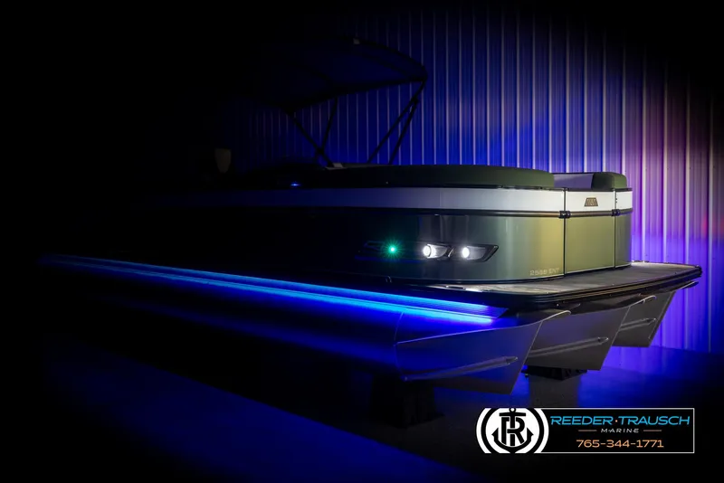 Slide: The Image of 2025 Avalon Catalina Entertainer pontoon boat with blue LED lights in a dimly lit setting. - 4