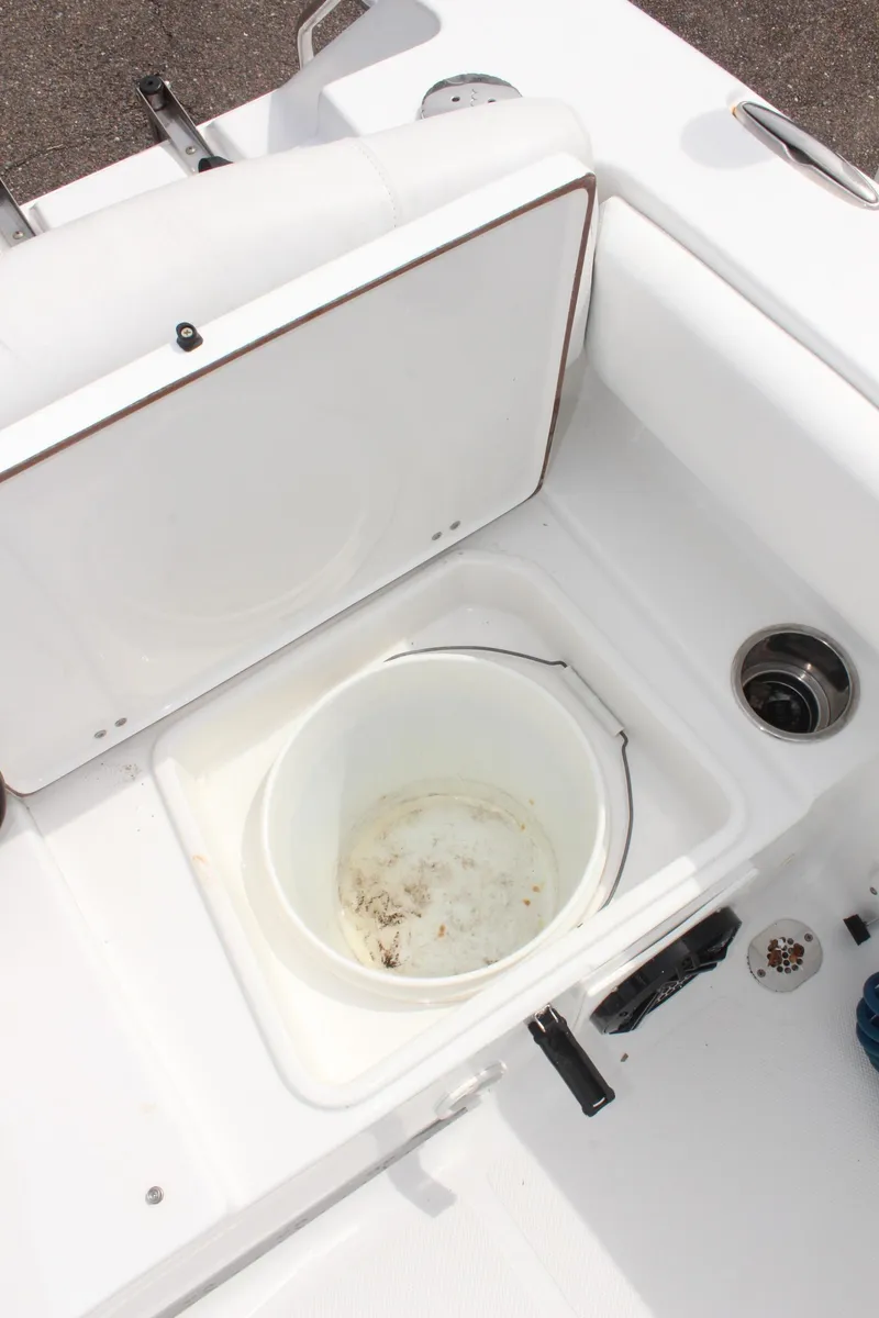 Slide: The Image of 2015 Sea Hunt Ultra 235 SE boat storage compartment with bucket. - 11