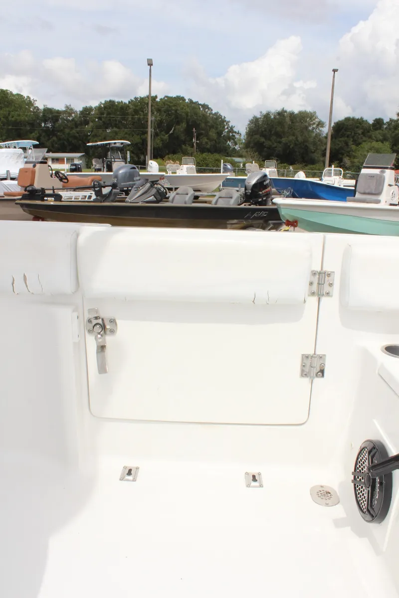Slide: The Image of 2015 Sea Hunt Ultra 235 SE boat interior, showcasing clean white seating and storage area. - 15