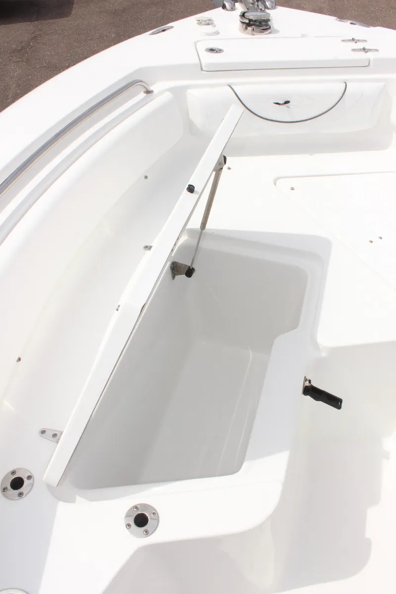 Slide: The Image of 2015 Sea Hunt Ultra 235 SE boat storage compartment, open lid, white interior. - 29
