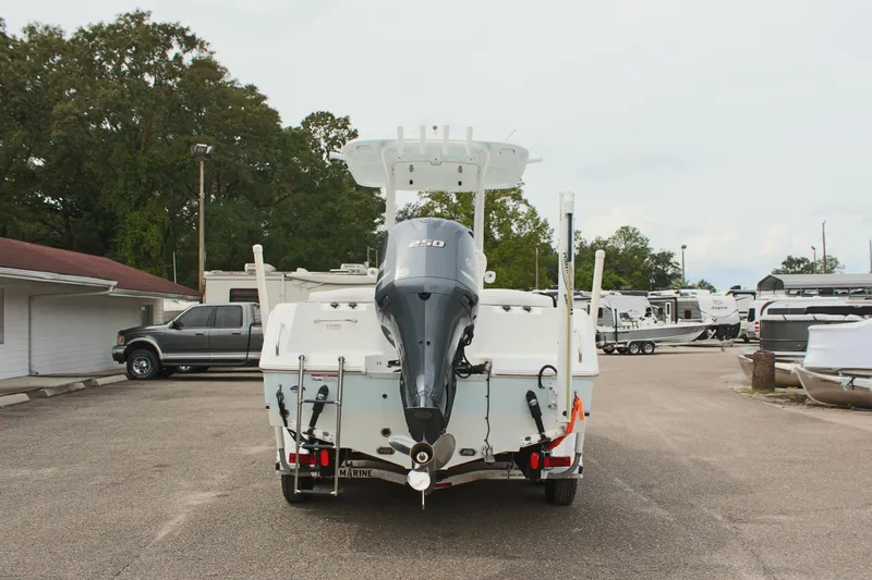 Slide: The Image of 2015 Sea Hunt Ultra 235 SE boat with outboard motor, parked in a marina. - 6