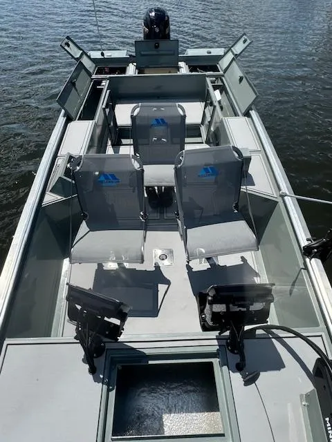 Slide: The Image of Custom Ultimate Panfish XL 2025 fishing boat with seating and equipment on a calm lake. - 10
