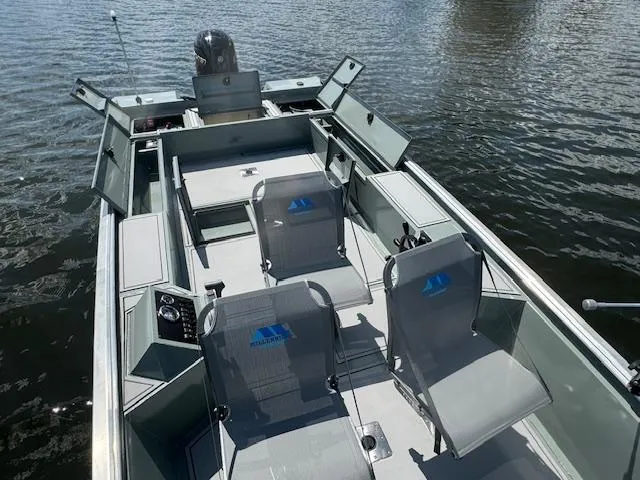 Slide: The Image of Custom Ultimate Panfish XL 2025 boat with open compartments on a calm lake. - 11