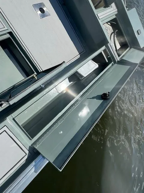 Slide: The Image of Custom Ultimate Panfish XL 2025 boat with open storage compartments on the water. - 13