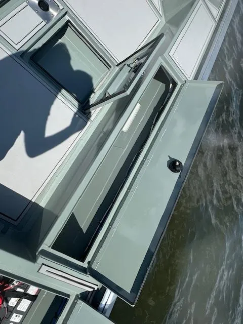 Slide: The Image of Custom Ultimate Panfish XL 2025 boat with open storage compartments on the water. - 15