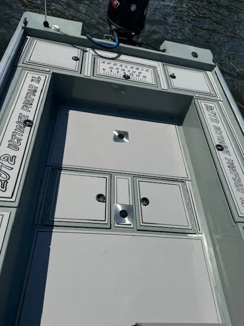 Slide: The Image of Custom Ultimate Panfish XL 2025 boat deck with storage compartments on the water. - 24