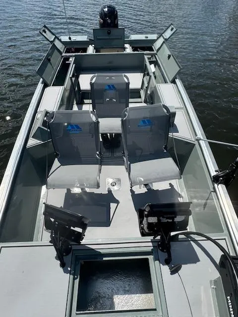 Slide: The Image of Custom Ultimate Panfish XL 2025 fishing boat with seating and storage on a lake. - 9