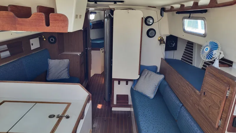 Slide: The Image of Interior of a 1979 Pearson 365 Sloop sailboat with blue seating and wooden accents. - 16